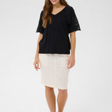 Woman wearing a black top and white skirt on a white background