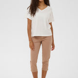 Woman wearing a white top and beige pants on a white background