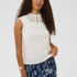 Woman wearing a white lace top and blue floral skirt on a white background