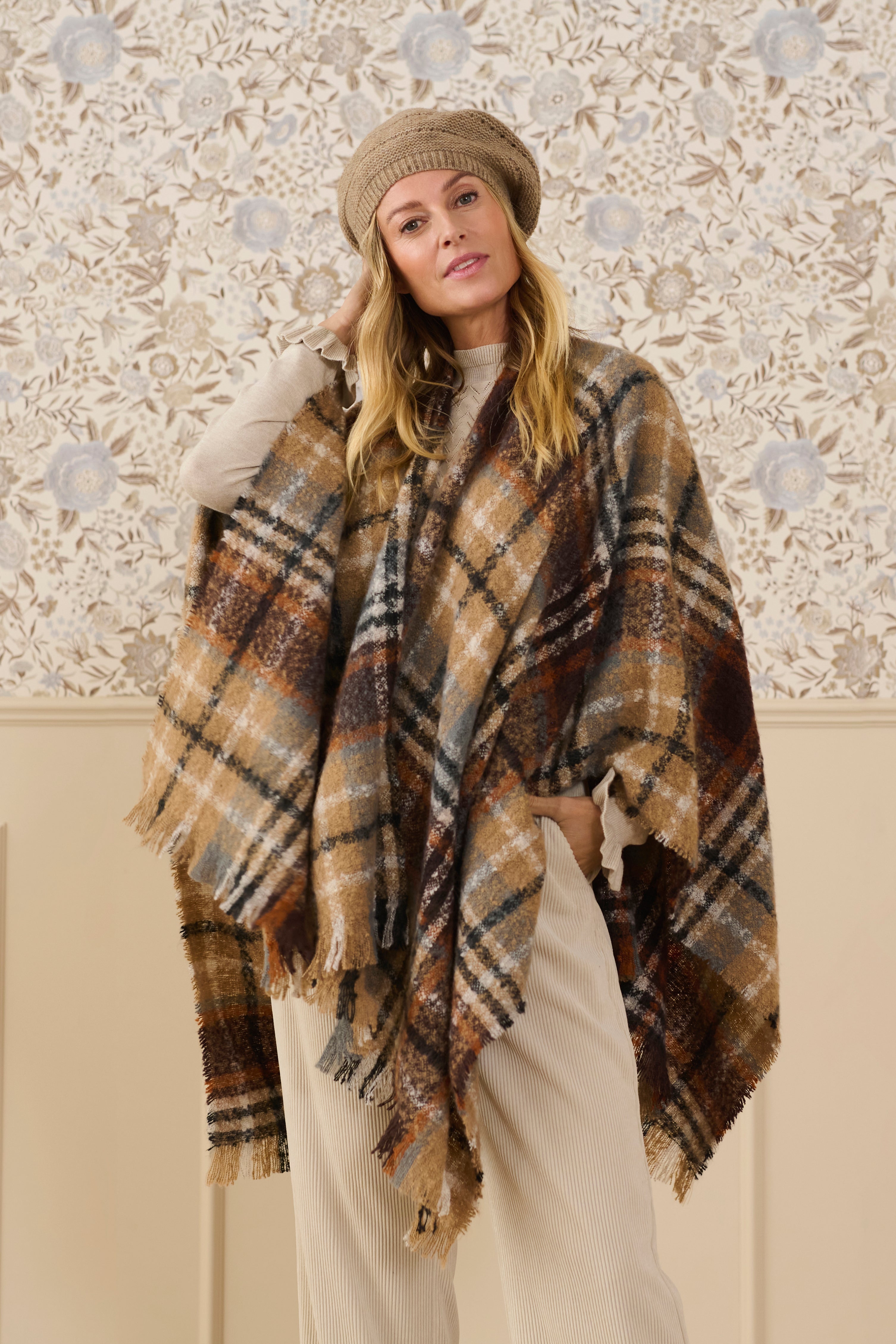 Upgrade your wardrobe with our Cream Tika Cape. Made with luxurious plaid fabric, this cape will wrap you in both comfort and style. Perfect for any occasion, take your outfit to the next level with this versatile and fashionable piece.