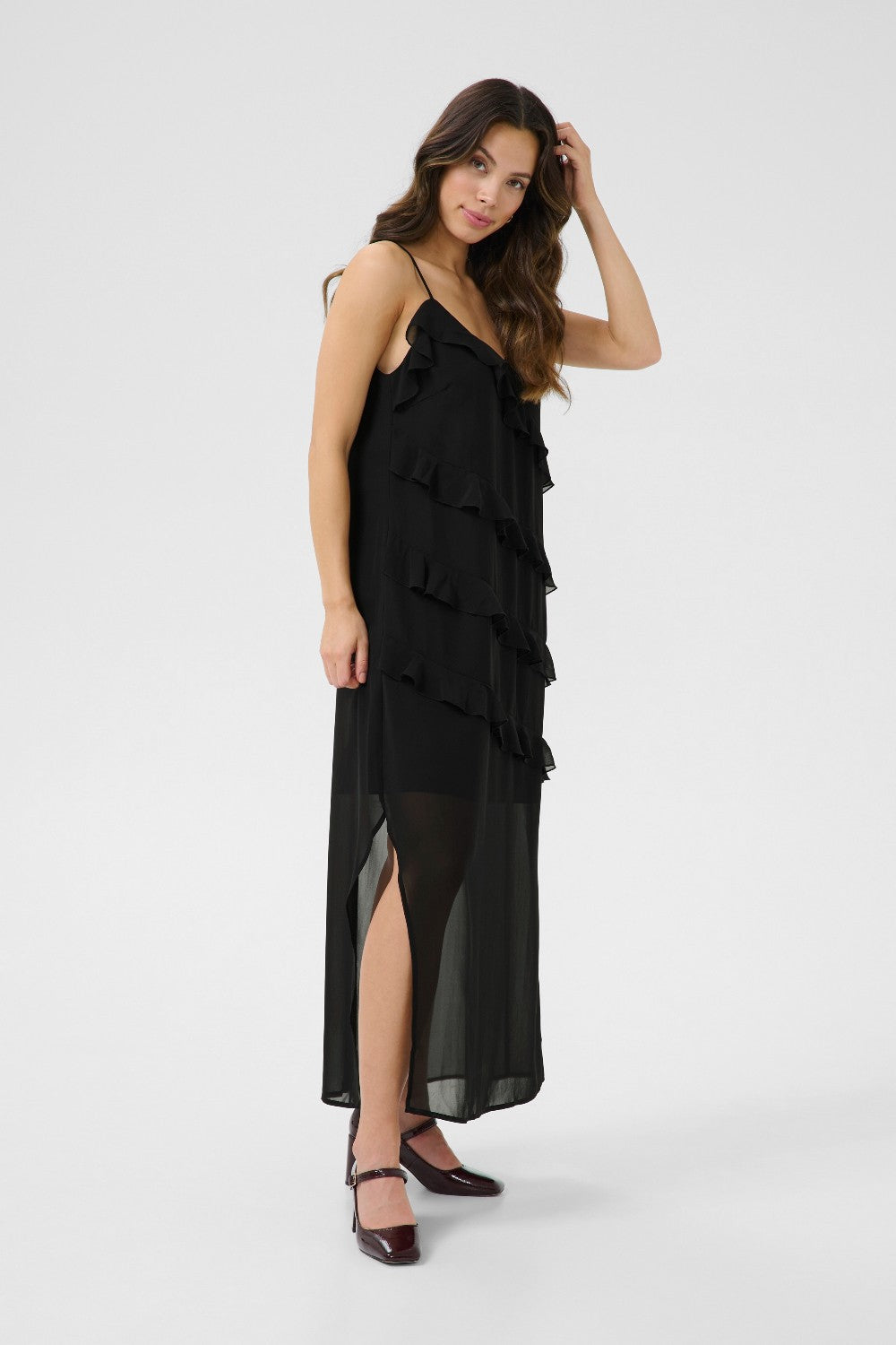 Woman wearing a black ruffled dress on a white background