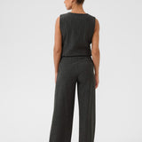 Person wearing a sleeveless top and high-waisted pants on a white background