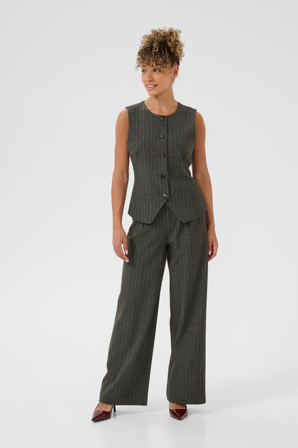 Woman wearing a gray pinstripe suit on a white background