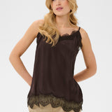 Woman wearing a brown sleeveless top with lace details on a white background