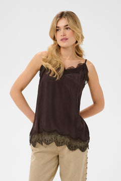 Woman wearing a brown sleeveless top with lace details on a white background