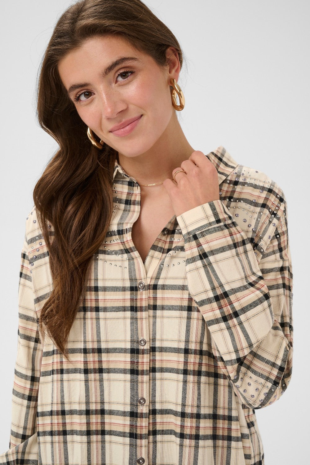 Woman wearing a plaid shirt against a white background