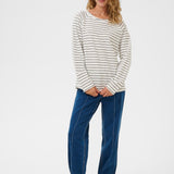 Woman wearing a striped long-sleeve shirt and blue jeans on a white background