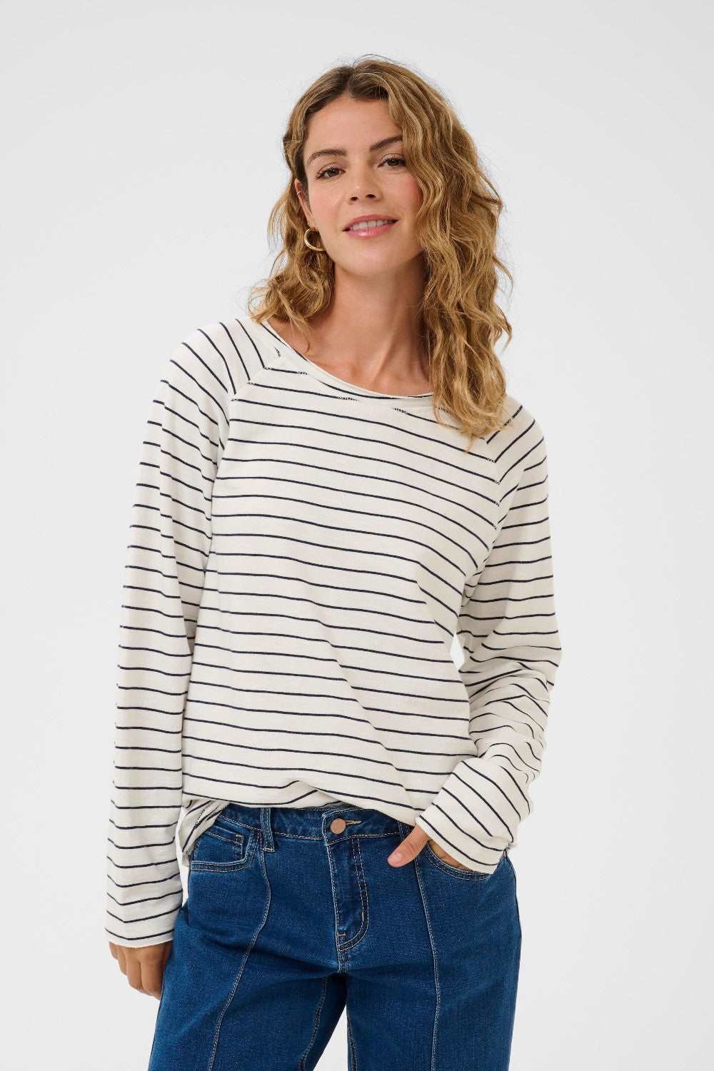 Woman wearing a striped long-sleeve shirt and blue jeans on a white background