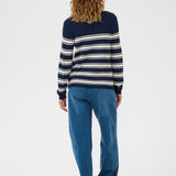 Person wearing a navy and white striped sweater and blue jeans on a white background