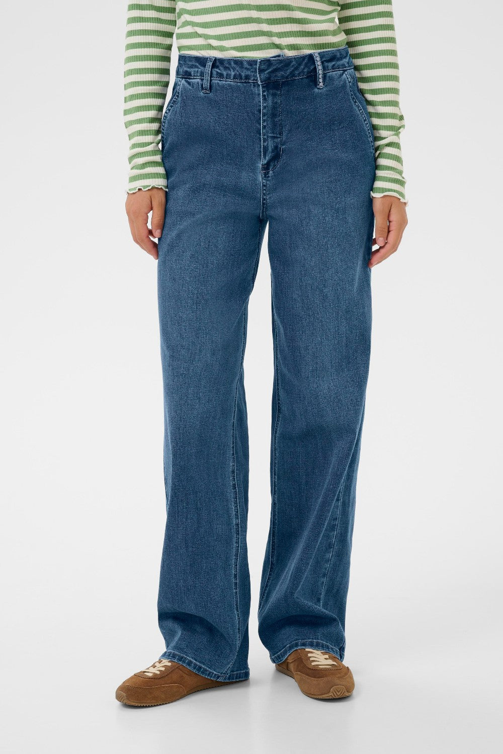 Person wearing blue jeans and a green and white striped shirt on a white background