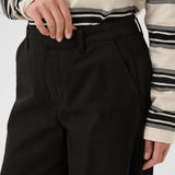 Person wearing a striped shirt and black pants on a white background