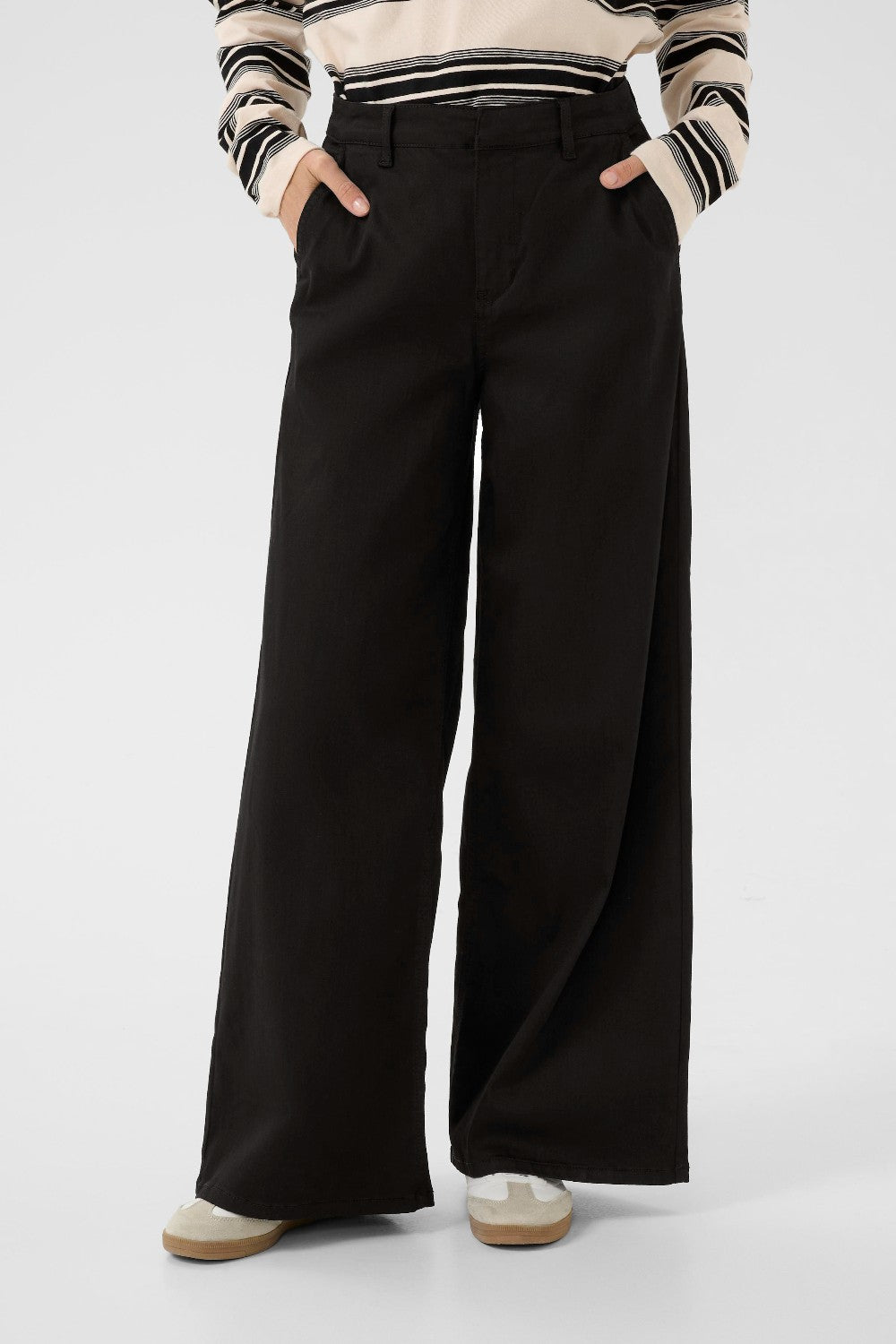 Person wearing black wide-leg pants with a striped sweater on a white background