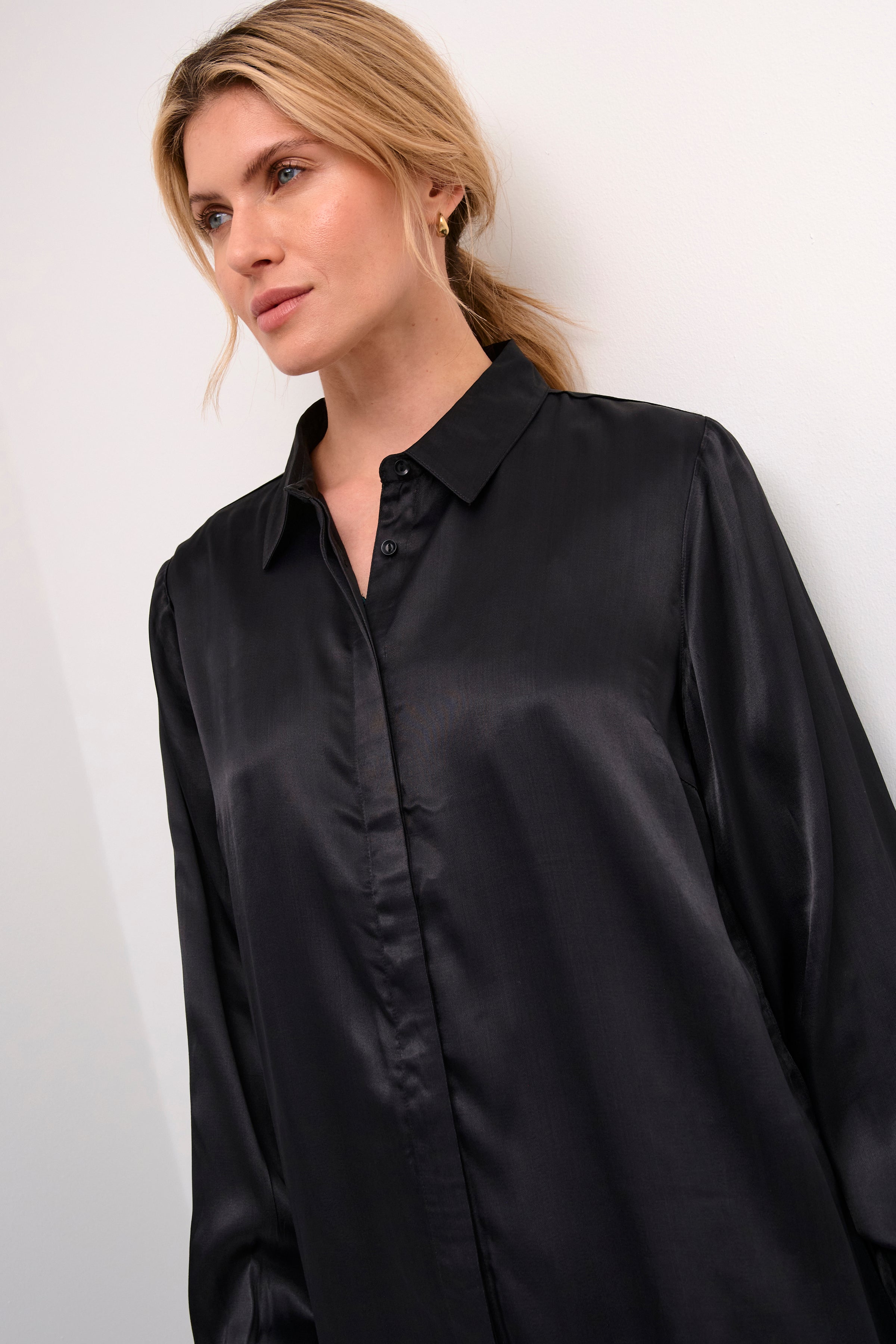 The Cream Wendy Shirt is a must-have for any special occasion. Made with high-quality sateen fabric with a full button front, this shirt offers an elegant touch and maintains a professional appearance. Its long body adds a luxurious feel to any outfit. Elevate your style with this essential wardrobe piece.