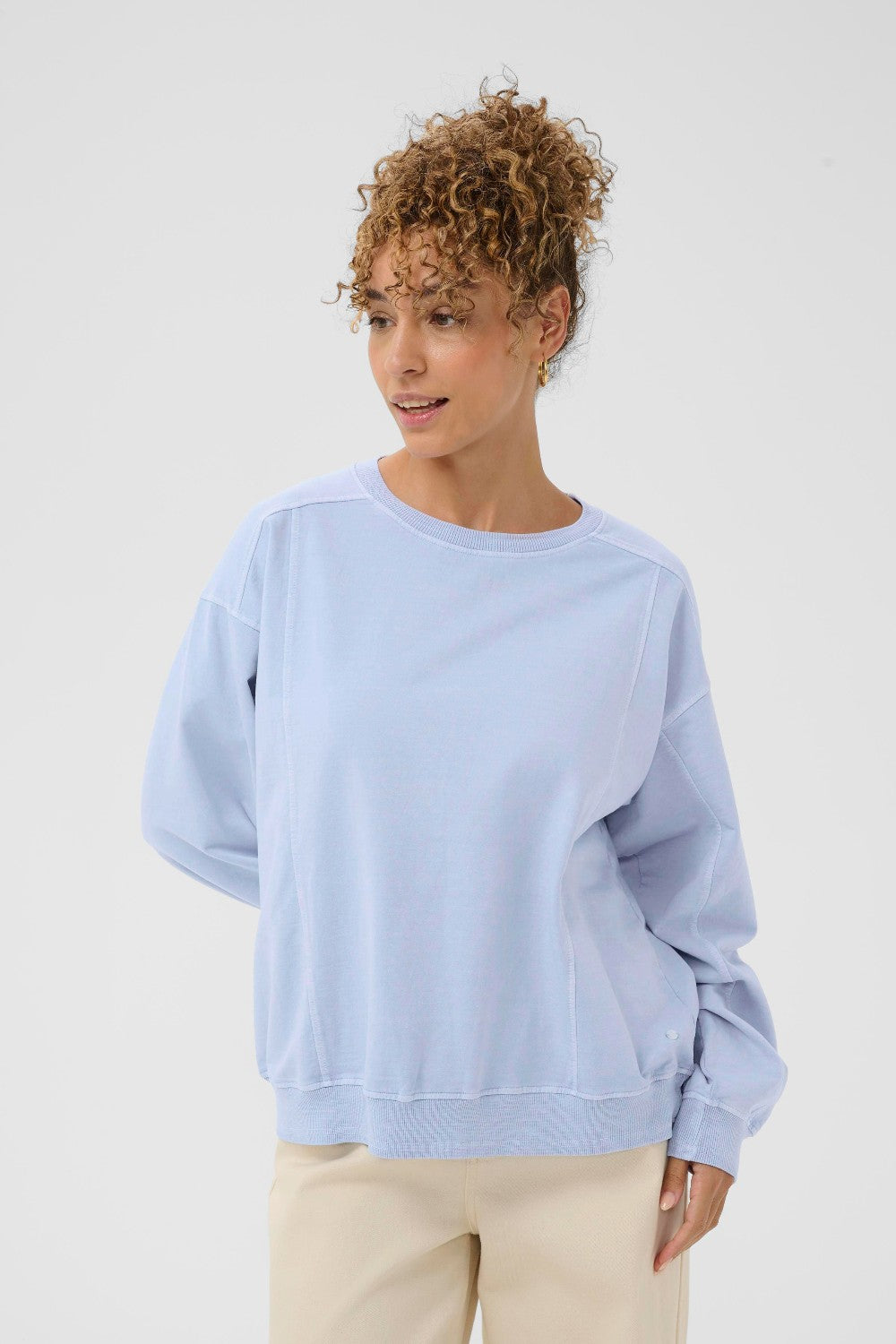 Woman wearing a light blue sweatshirt on a white background