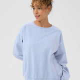 Woman wearing a light blue sweatshirt on a white background