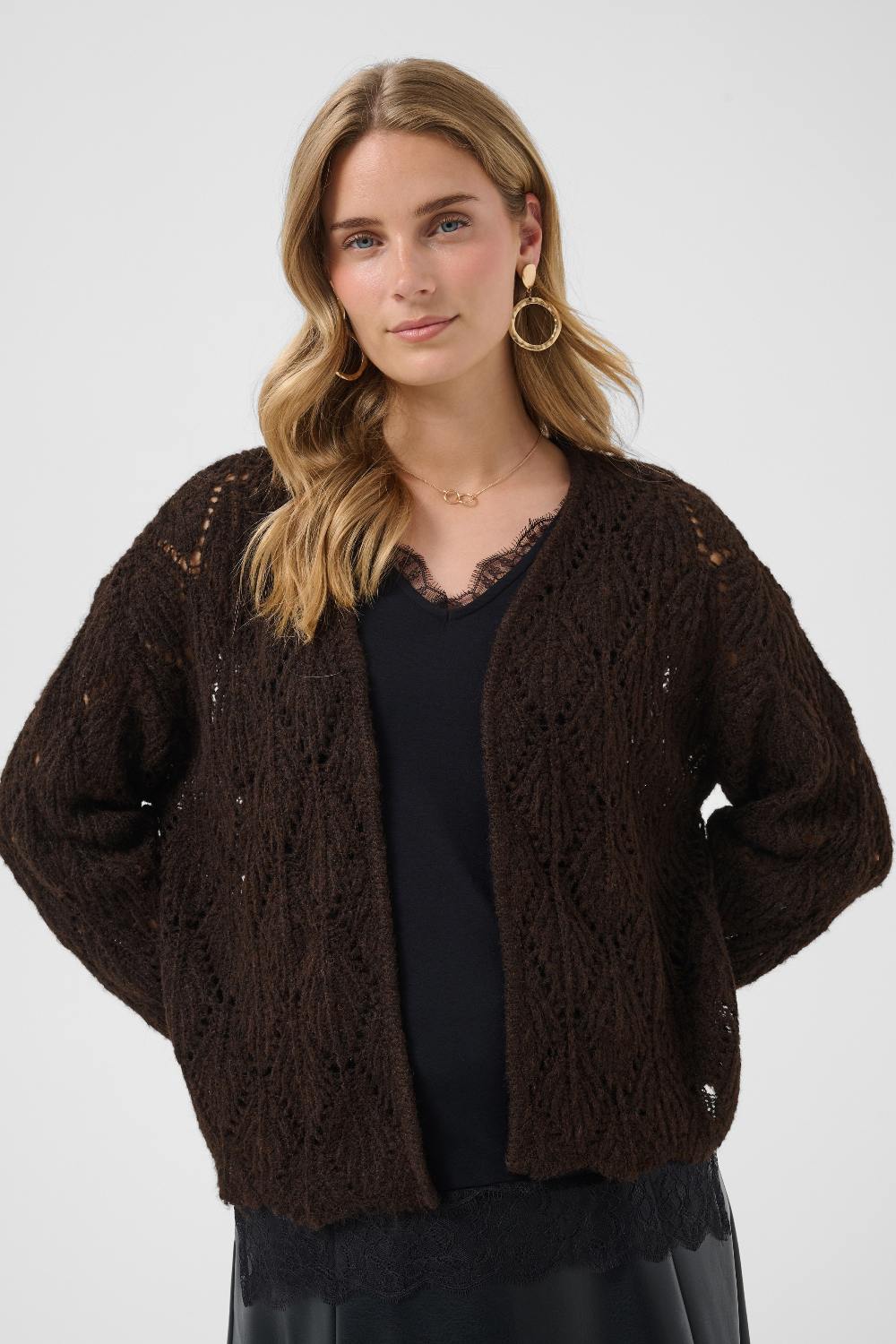 Woman wearing a brown knitted cardigan on a white background
