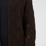 Brown cardigan over a black top on a white background