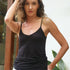 Woman wearing a black tank top and white pants outdoors