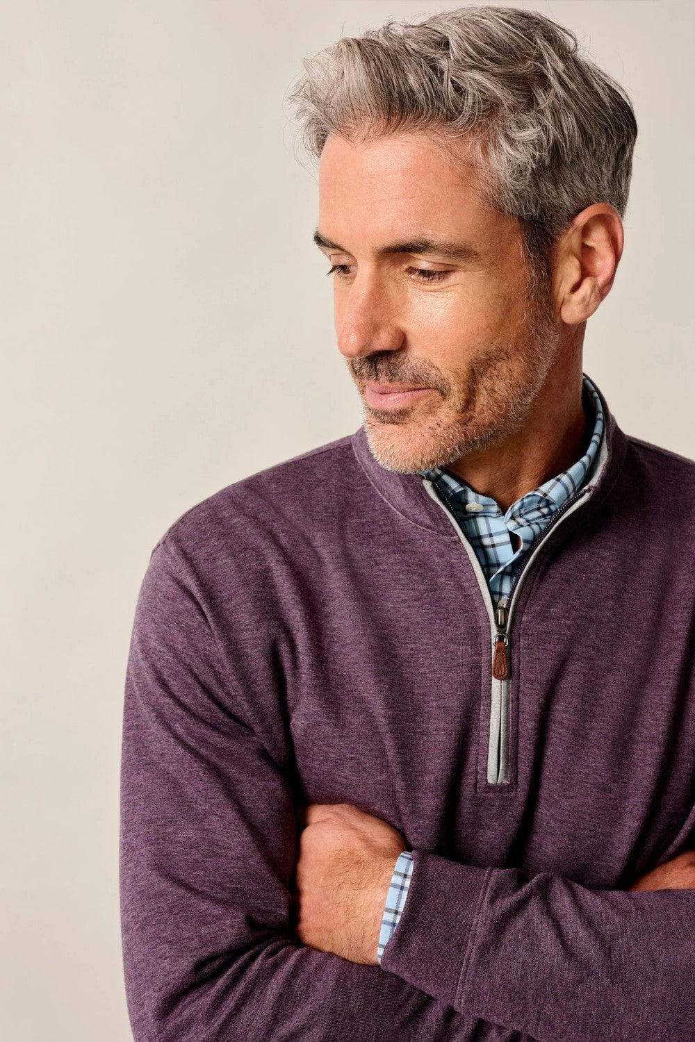 Man wearing a purple sweater with a beige background