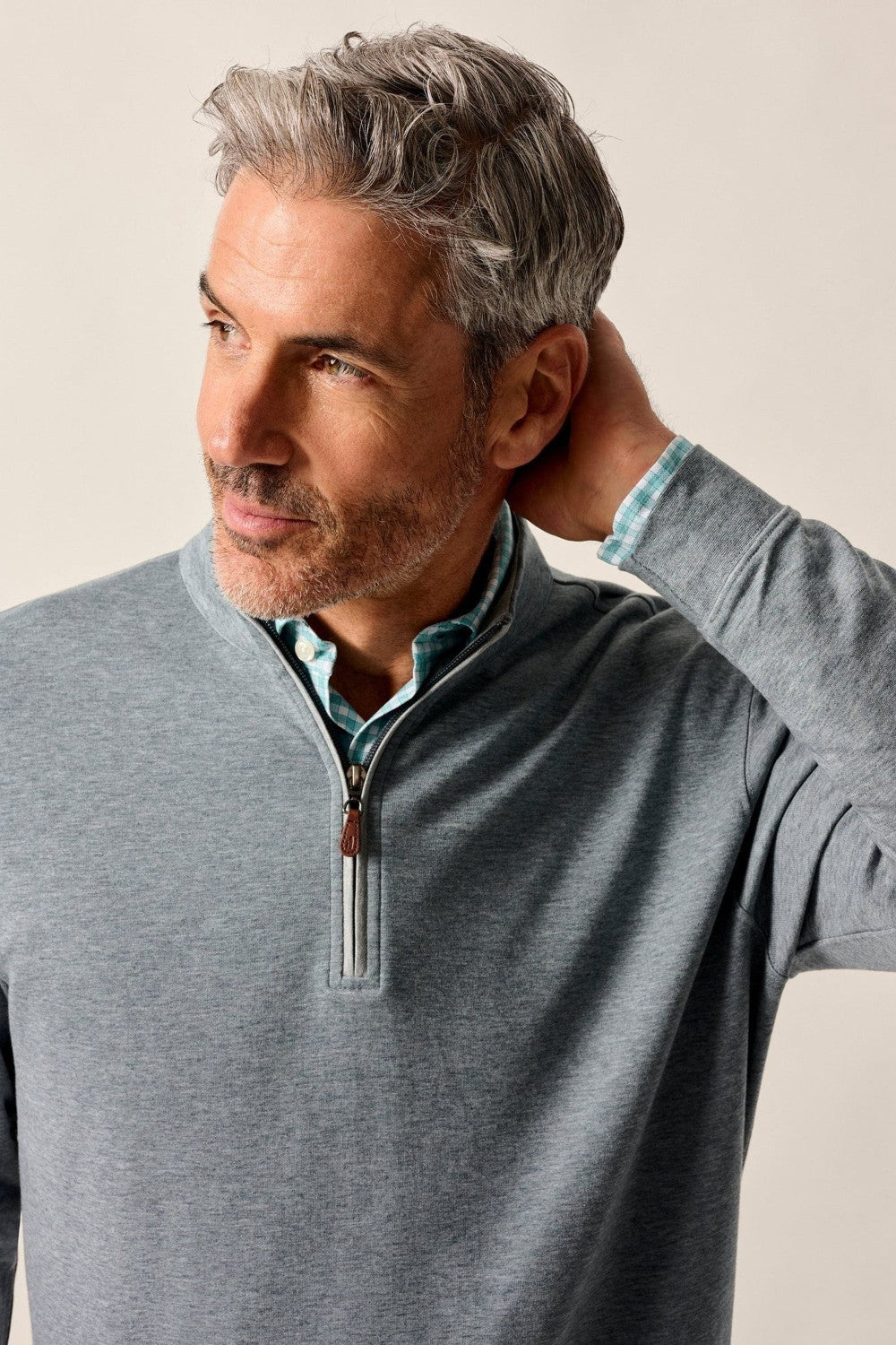 Man wearing a gray zip-up sweater against a plain background