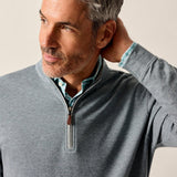 Man wearing a gray zip-up sweater against a plain background