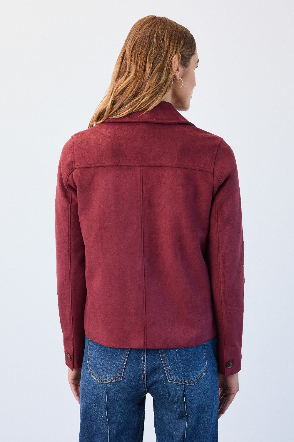Person wearing a red jacket and blue jeans on a white background