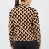Woman wearing a patterned blouse with black and beige design on a white background