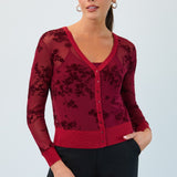 Woman wearing a red floral cardigan against a light gray background