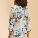 Woman wearing a patterned top against a beige background