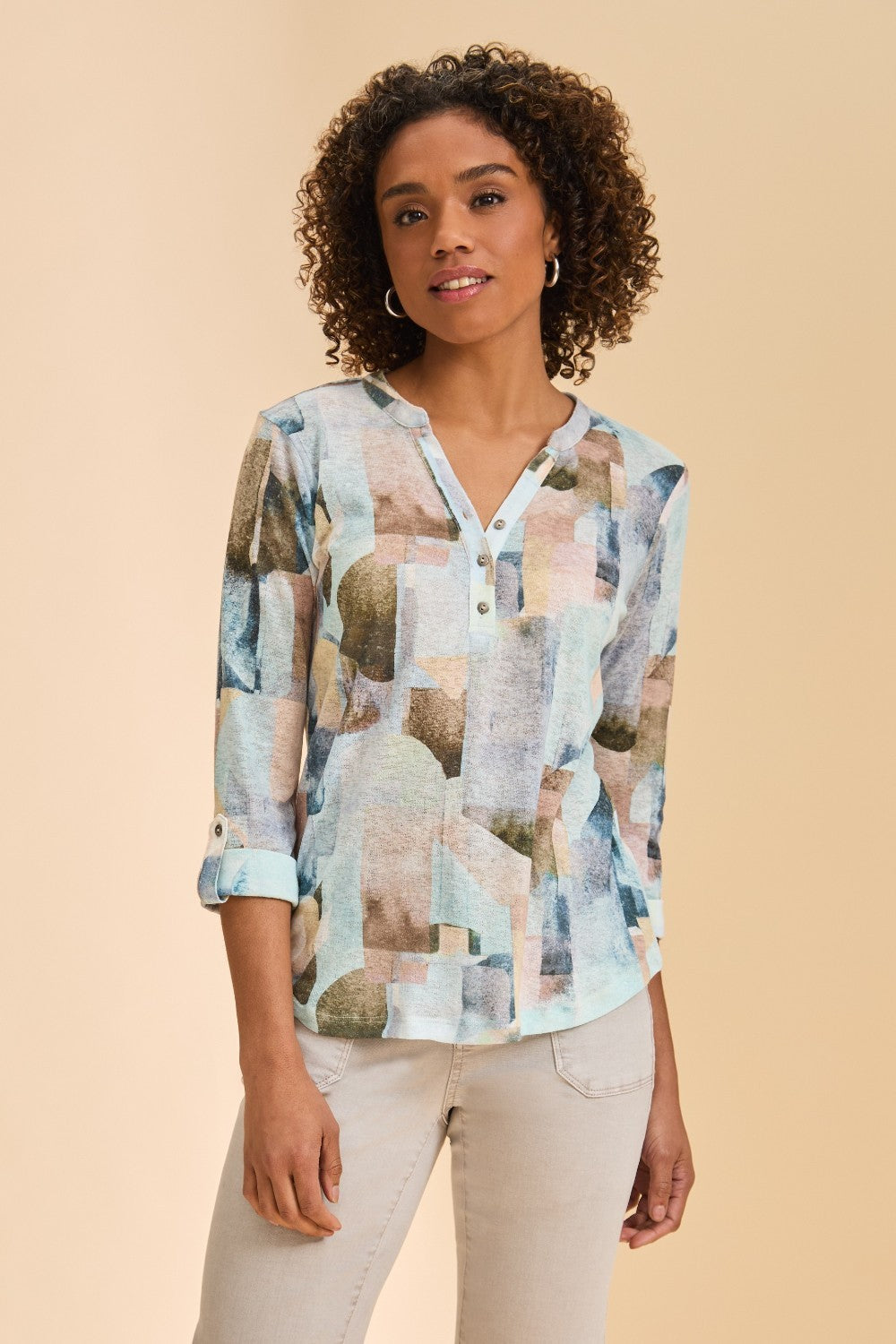 Woman wearing a patterned top against a beige background