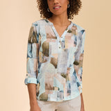 Woman wearing a patterned top against a beige background