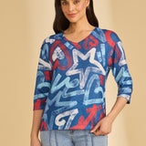 Woman wearing a blue abstract patterned top against a beige background