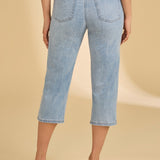 Light blue jeans worn by a person on a beige background