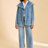 Woman wearing a denim outfit on a beige background