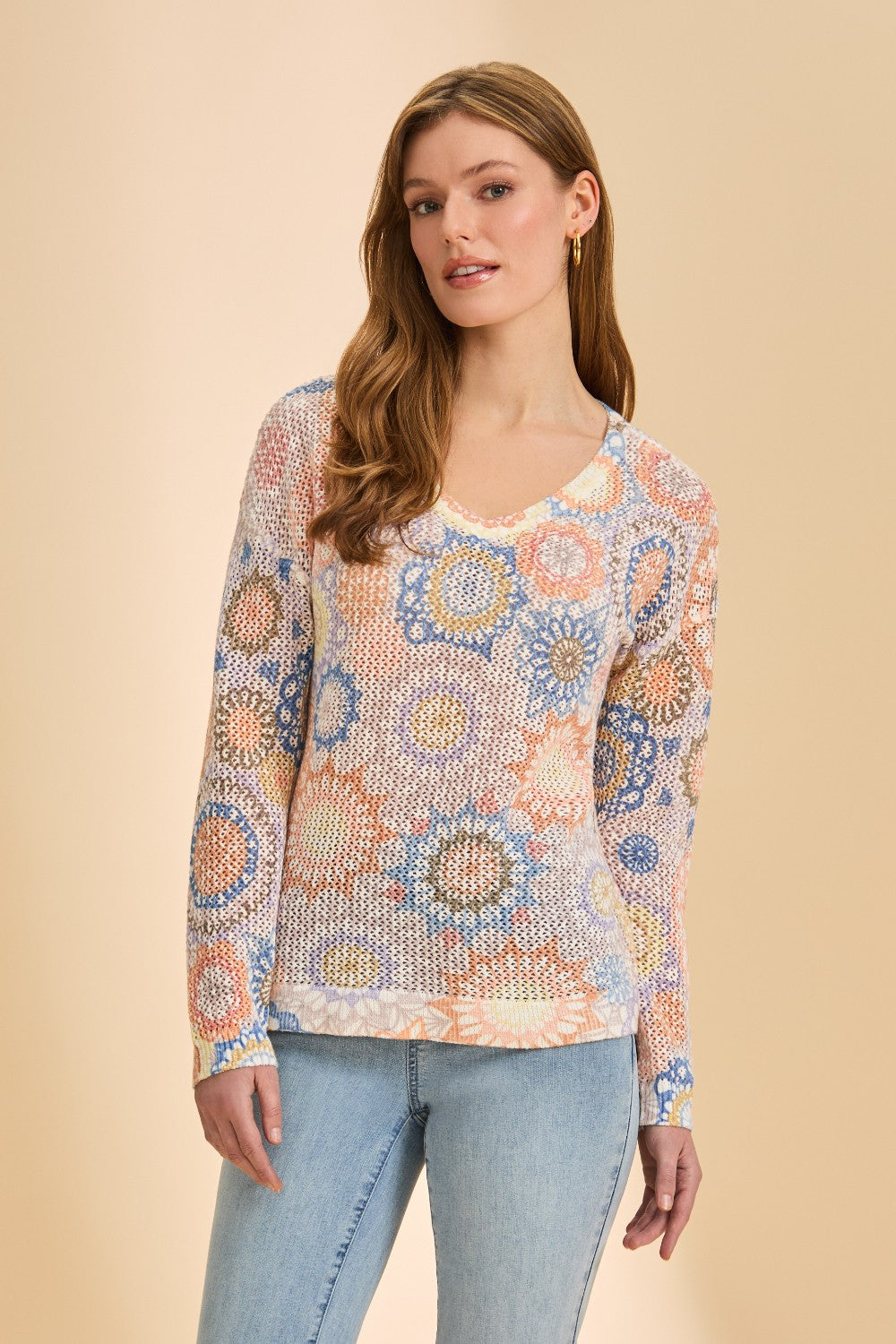 Woman wearing a colorful patterned sweater against a beige background