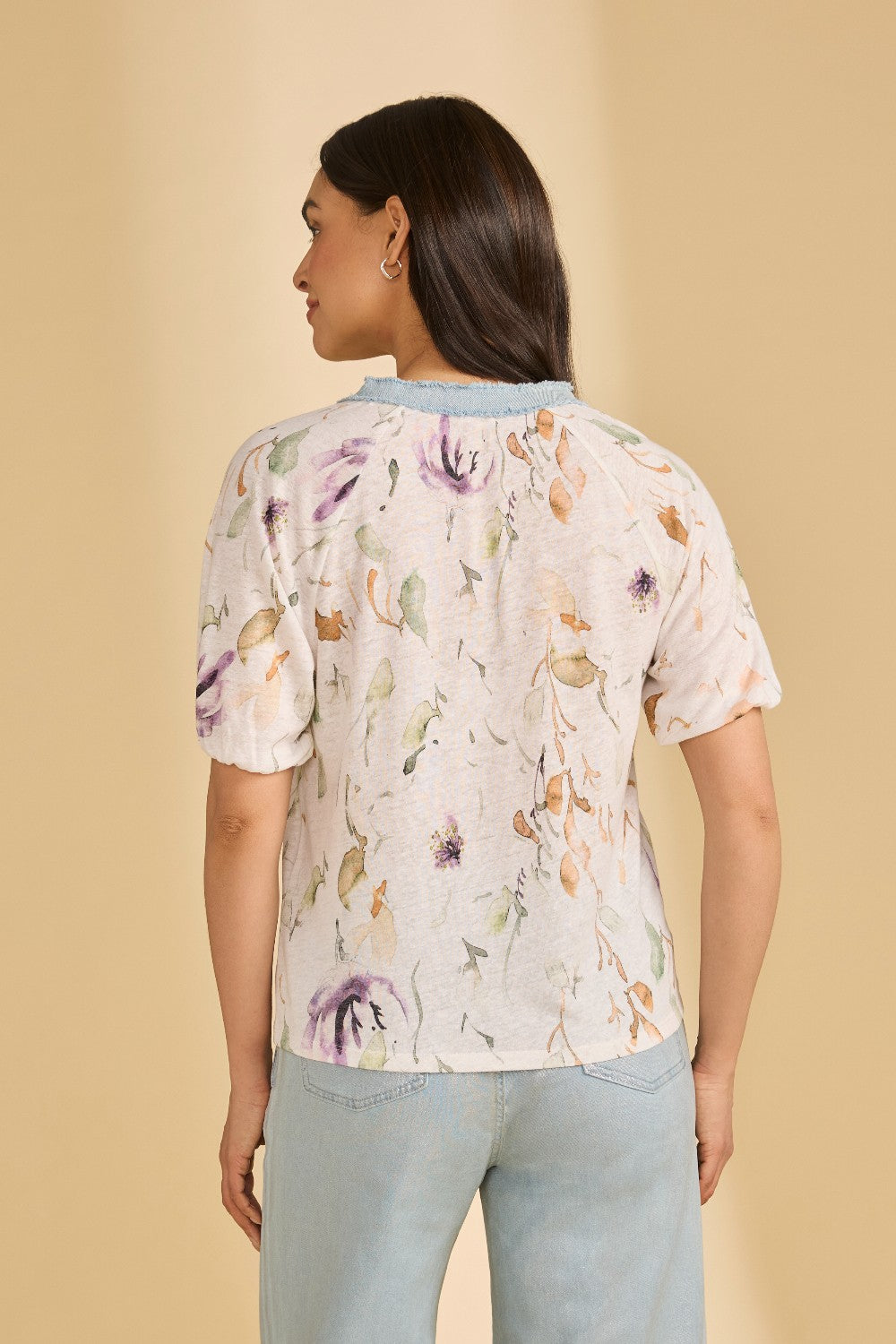 Woman wearing a floral top with a beige background