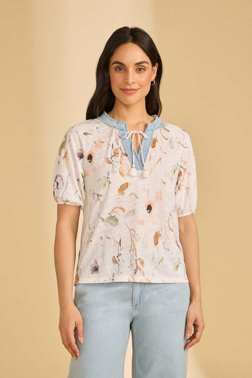 Woman wearing a floral top with a beige background