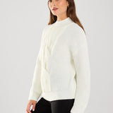 This cable knit sweater features delicate pearl embellishments, adding a touch of sophistication to a classic design.