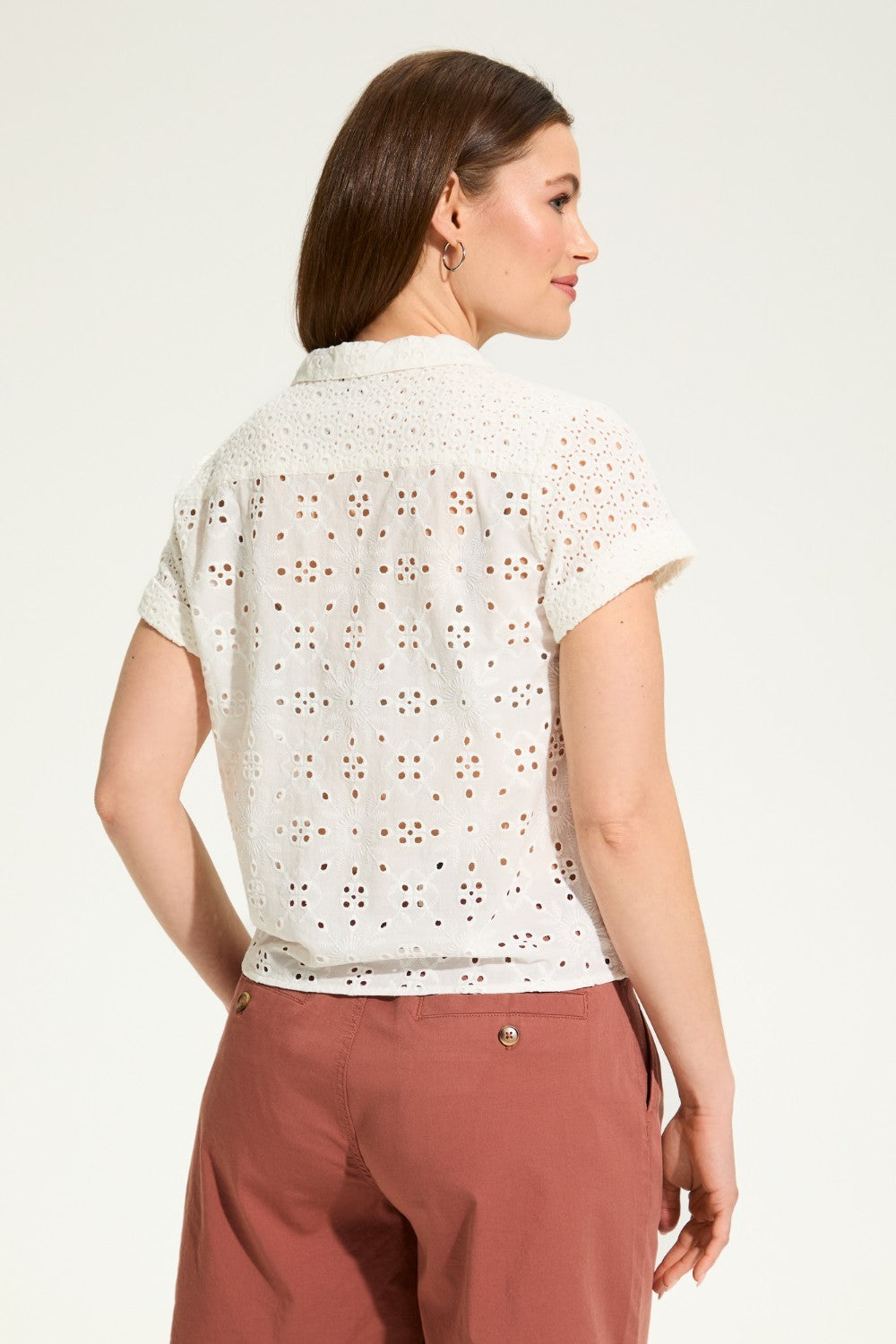 This 100% cotton top exudes effortless style with its eyelet lace detailing and playful tie at the front. A versatile choice for any casual occasion.