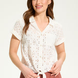 This 100% cotton top exudes effortless style with its eyelet lace detailing and playful tie at the front. A versatile choice for any casual occasion.