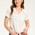 This 100% cotton top exudes effortless style with its eyelet lace detailing and playful tie at the front. A versatile choice for any casual occasion.