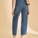 Person wearing blue jeans on a beige background