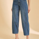 Person wearing blue jeans on a beige background