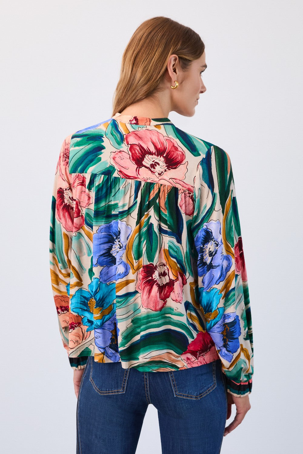 Woman wearing a colourful floral top on a white background
