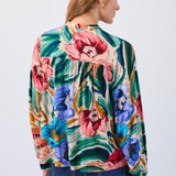 Woman wearing a colourful floral top on a white background