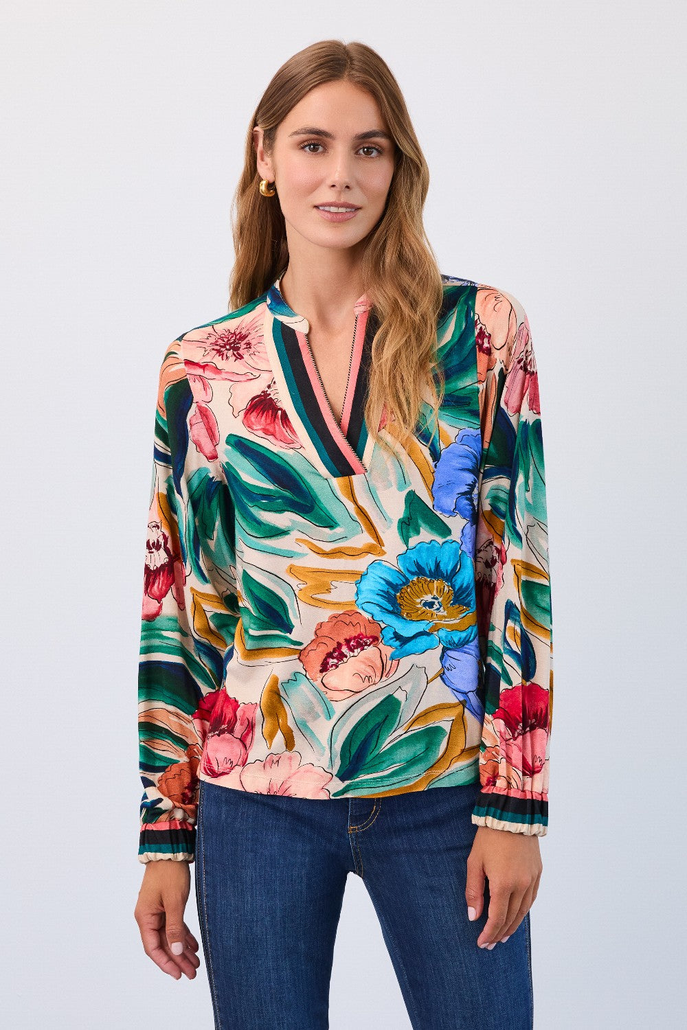 Woman wearing a colourful floral blouse with a plain background
