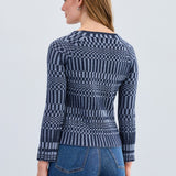 Woman wearing a blue patterned sweater and jeans on a white background