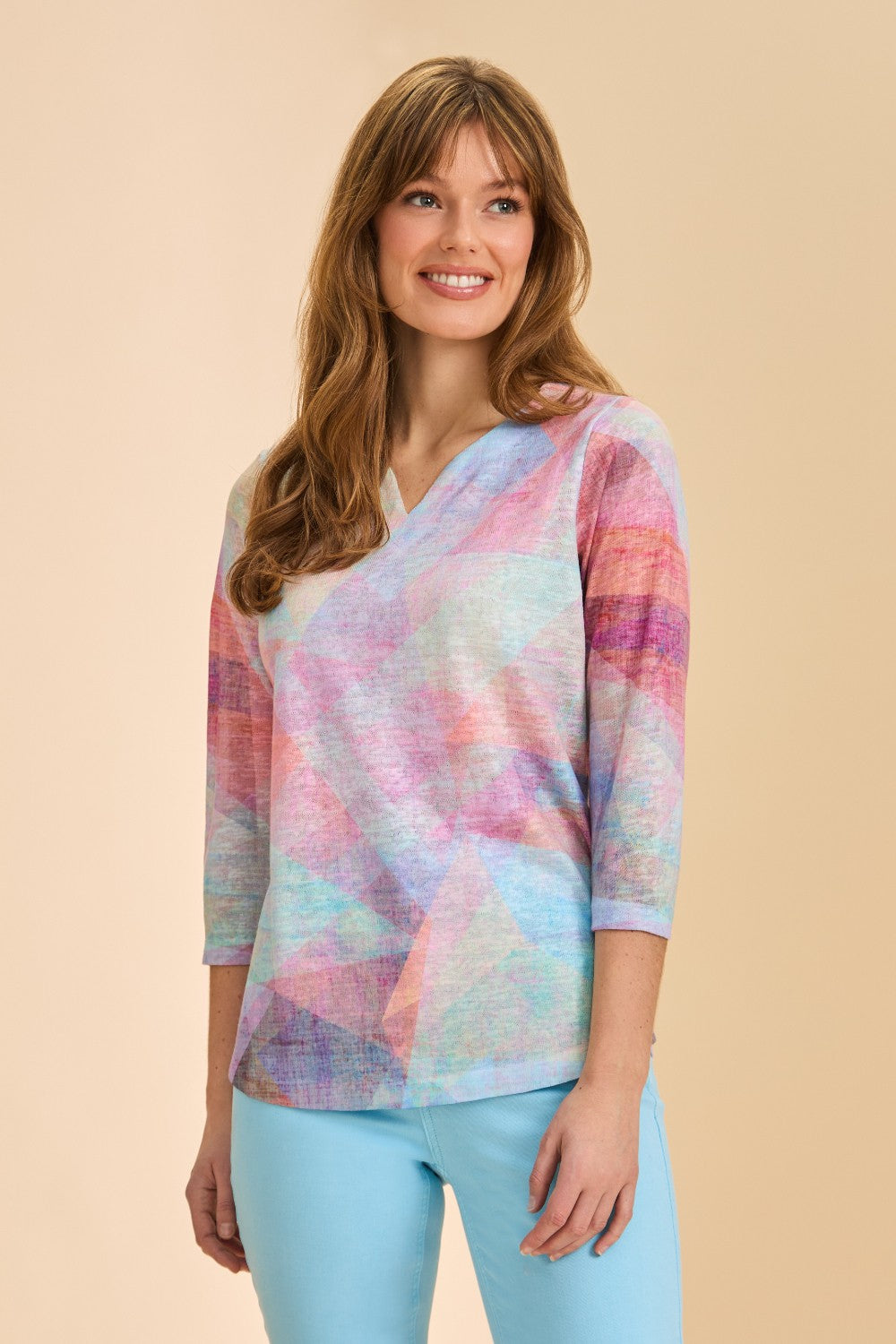 Woman wearing patterned notch neck top with 3/4 sleeves with a blue pant