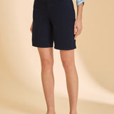 Person wearing navy shorts and a striped shirt on a beige background