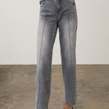 Woman wearing a gray wide leg jean with a printed top and pumps on a neutral background.